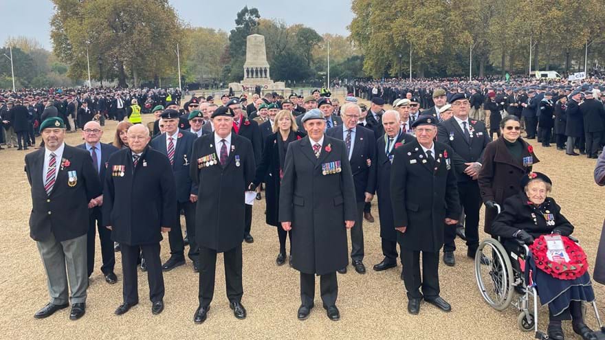 Blind veterans and guides gathered together, wearing their badges and poppys for Remembrance