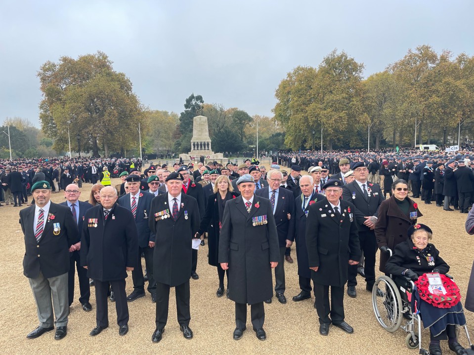 Blind veterans and guides gathered together, wearing their badges and poppys for Remembrance
