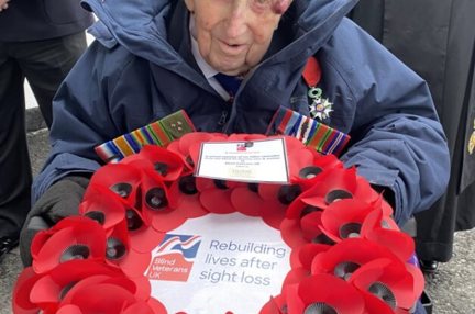 Ken in his beret and holding a poppy wreath 