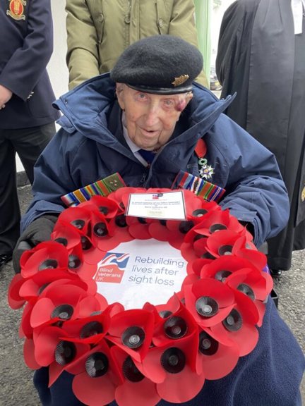 Ken in his beret and holding a poppy wreath